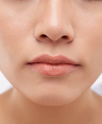 Close-up image of beautiful un young woman with flawless nude make-up and lip gloss
