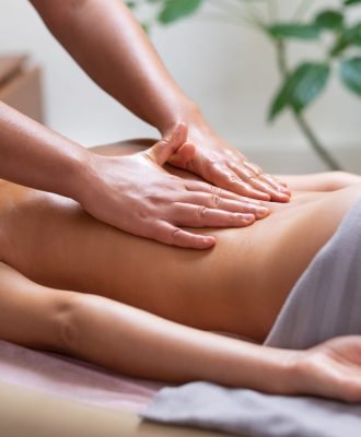Caucasian woman getting a back massage in the spa salon. Body care concept.