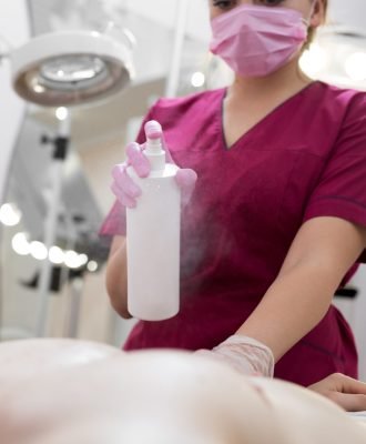Close-up of mens Breasts in the beauty salon for the procedure of sugar hair removal. Beautician sprays disinfectant solution on the man's chest. Sugaring