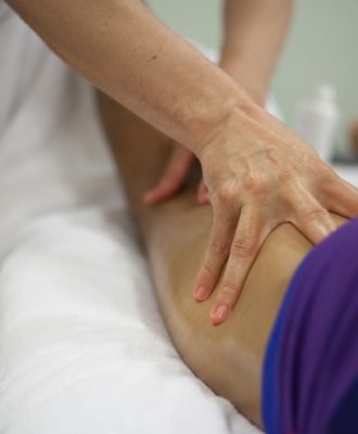 physiotherapist applying massage on the back of the leg