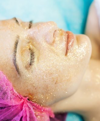 Spa therapy for young woman having facial mask at beauty salon