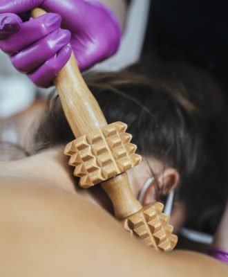 Working Safely During Coronavirus Crisis. Masseuse massaging client with gloves and face visor at Beauty Spa Wellness Center during COVID-19 pandemic