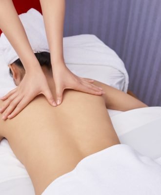 Unrecognizable young woman with beautiful skin having relaxing massage in modern spa salon, high angle shot